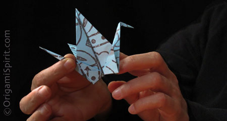 Manos sosteniendo una grulla de origami