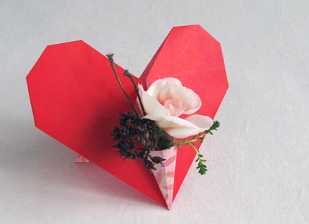 Red origami heart with a bouquet of flowers