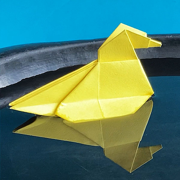 An origami duck  floating on water