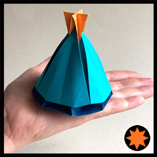 An origami model titled "Festive Bell Box" designed by Leyla Torres